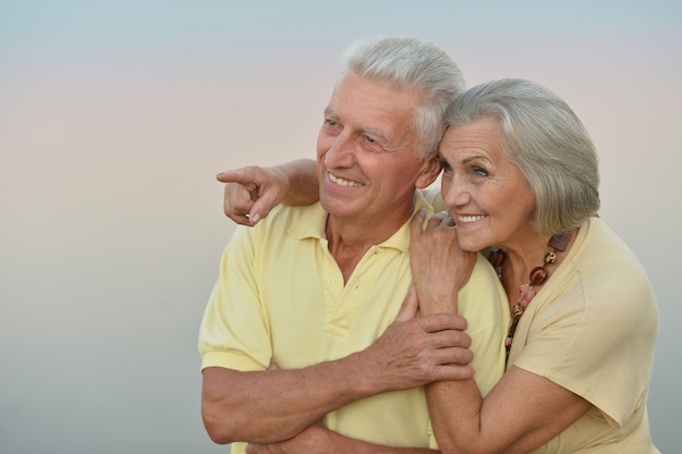 Hermosa pareja de ancianos en el fondo del cielo, fondo borroso