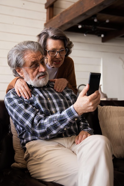 Una hermosa pareja de ancianos y un gadget moderno abuelos ancianos pasan el tiempo divirtiéndose usando smar