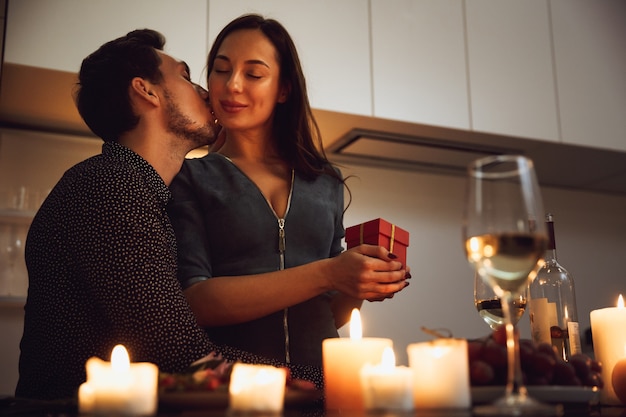 Hermosa pareja apasionada con una cena romántica a la luz de las velas en casa, besos