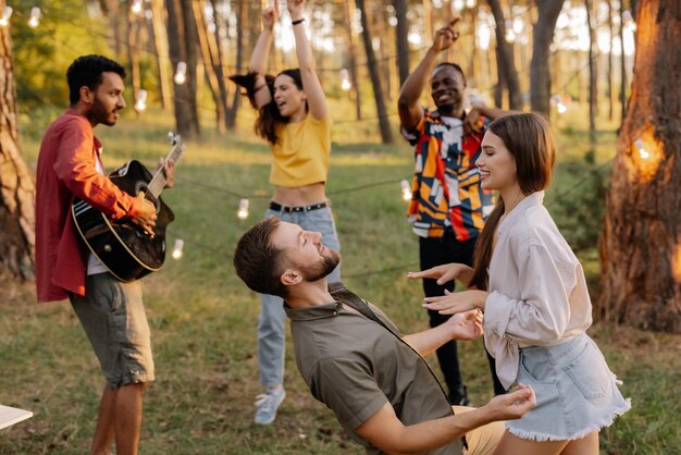 Una hermosa pareja bailando en el fondo de amigos divirtiéndose