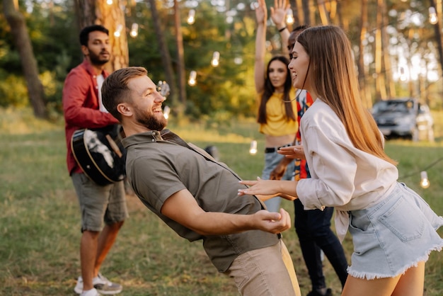 Una hermosa pareja bailando en el fondo de amigos divirtiéndose