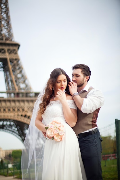 Hermosa pareja de bodas Novia y novio frente a la Torre Eiffel en París