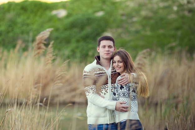 Hermosa pareja camina en otoño en la naturaleza, sentimientos sinceros reales