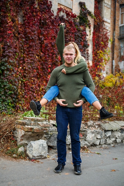 Hermosa pareja caminando por la calle en suéteres y jeans