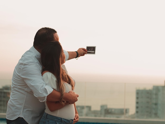 Hermosa pareja casada viendo el eco de su bebé en el camino