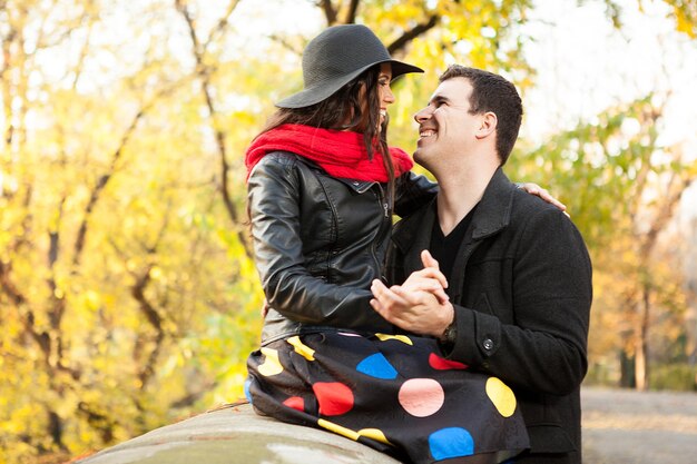 Hermosa pareja caucásica hermosa en el parque de otoño