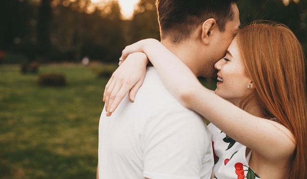 Hermosa pareja caucásica en ropa blanca abrazando y celebrando su cita juntos