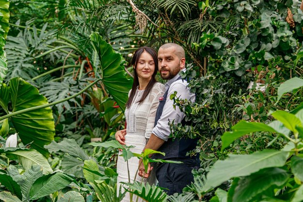 Hermosa pareja chica y chico en el parque entre árboles tropicales