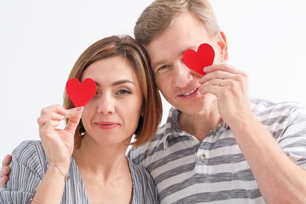 Hermosa pareja con corazones rojos en la pared de luz