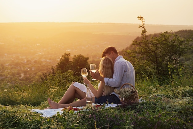 Hermosa pareja disfruta de un picnic al atardecer