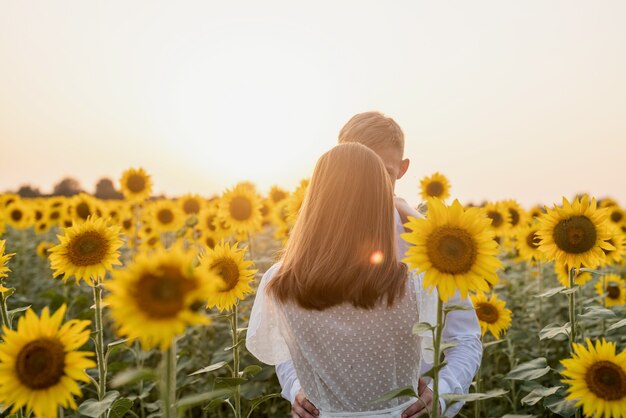 Hermosa pareja divirtiéndose en campos de girasoles