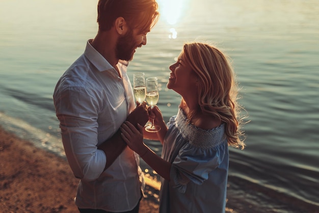 Hermosa pareja divirtiéndose en una cita al aire libre al atardecer