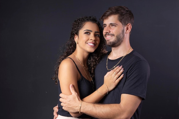 Hermosa pareja elegante joven y mujer en el estudio sobre un fondo negro