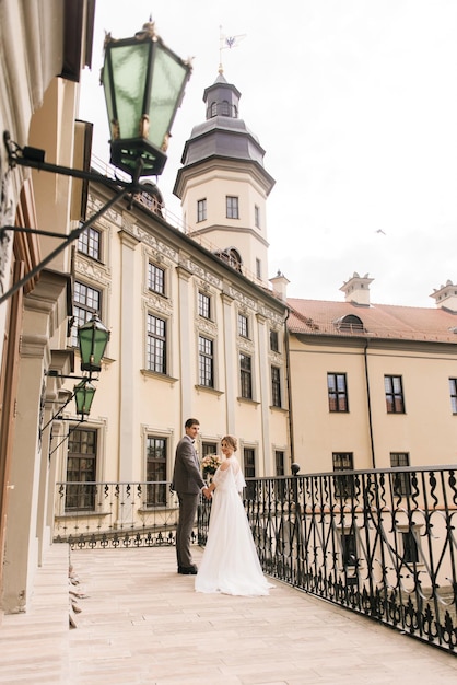 Hermosa pareja elegante de recién casados enamorados en el fondo de un edificio antiguo y adoquines Boda europea