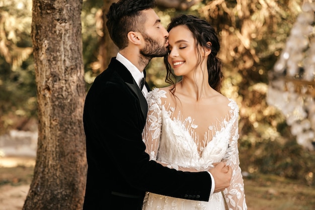 Hermosa pareja de enamorados besándose en el bosque, boda en el bosque. Boda para dos.