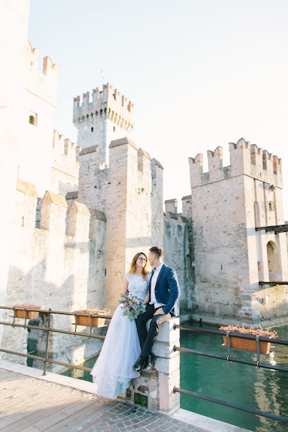 Hermosa pareja de enamorados caminando y besándose en Sirmione, Italia. Amor y ternura. Amor en Italia