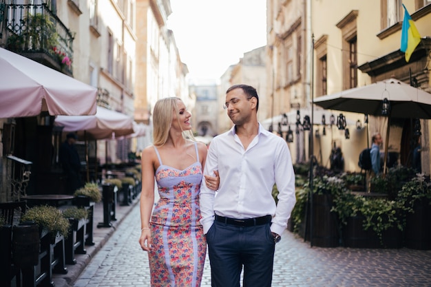 Hermosa pareja de enamorados saliendo al aire libre y sonriendo