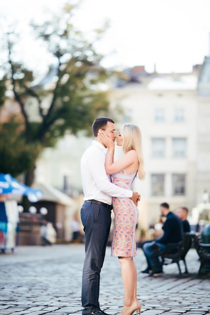 Hermosa pareja de enamorados saliendo al aire libre y sonriendo