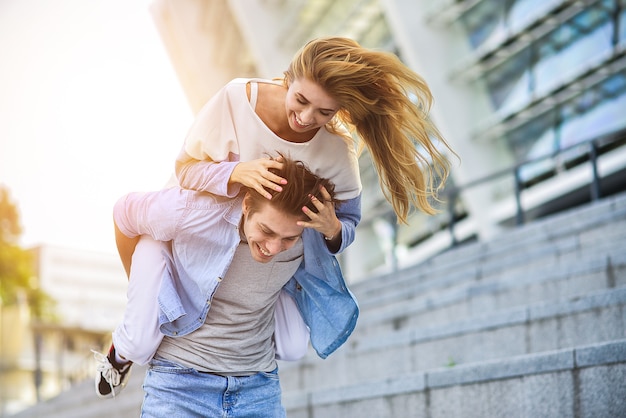 Hermosa pareja de enamorados saliendo al aire libre y sonriendo.