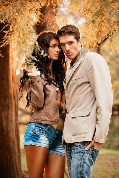 Foto hermosa pareja encantadora disfrutando en el parque en colores otoñales.