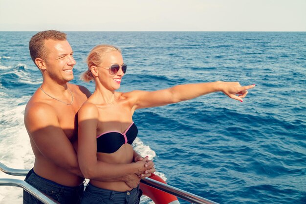 Hermosa pareja encantadora disfrutando en la terraza. Están en crucero y buscando lejos.