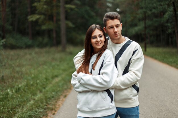 Hermosa pareja feliz en ropa elegante caminando en el parque