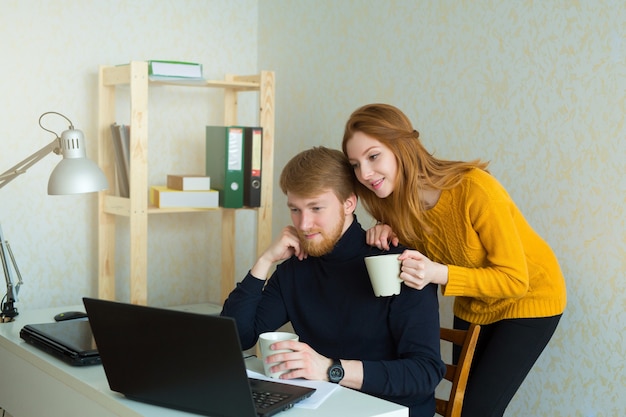 Hermosa pareja hombre y mujer trabajando en casa con portátiles