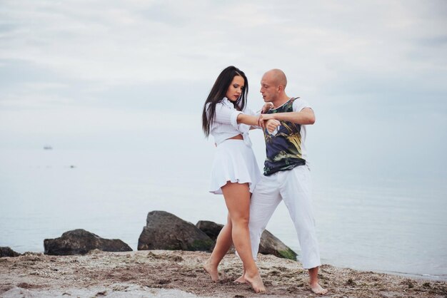 Foto una hermosa pareja inflamatoria bailando en la playa.