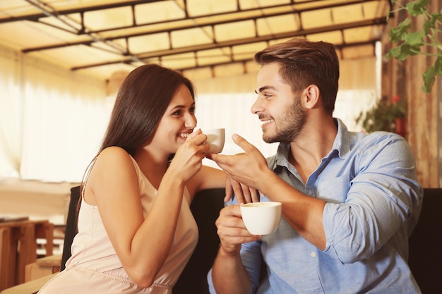 Hermosa pareja joven bebiendo café en la fecha