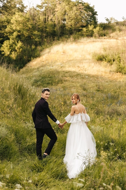 Hermosa pareja joven caminando en la naturaleza tomados de la mano foto de alta calidad