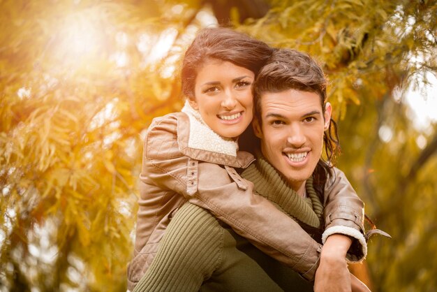 Hermosa pareja joven disfrutando del día de otoño en el parque.