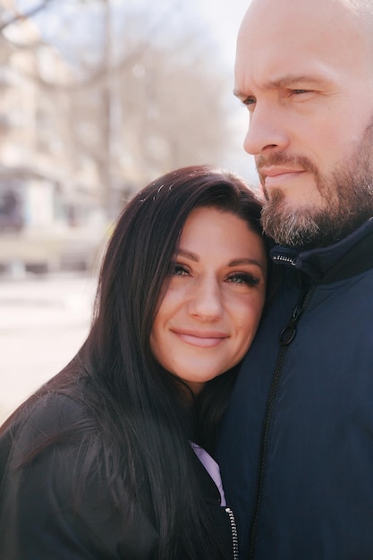 Hermosa pareja joven enamorada caminando al aire libre en la calle de la ciudad abrazándose