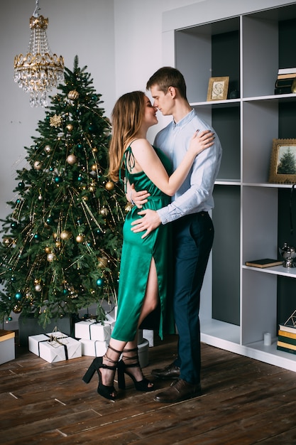 Hermosa pareja de lujo cerca de árbol de Navidad, año nuevo