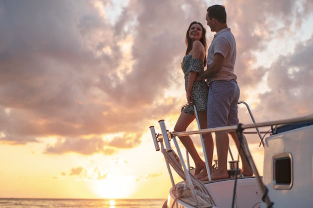 Foto hermosa pareja mirando el atardecer desde el yate