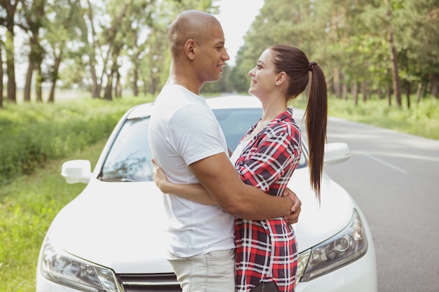 Hermosa pareja multirracial disfrutando de viajar en coche