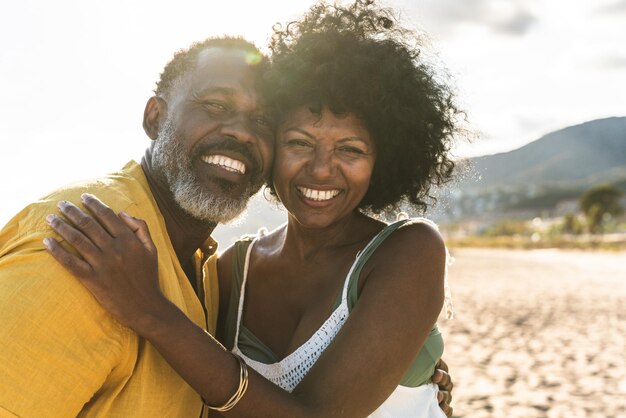 Una hermosa pareja negra madura de amantes saliendo en la orilla del mar