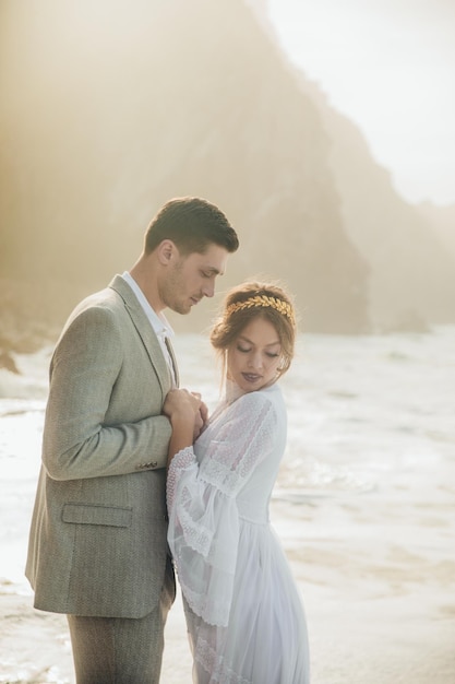 Hermosa pareja de novios de pie entre rocas enamoradas