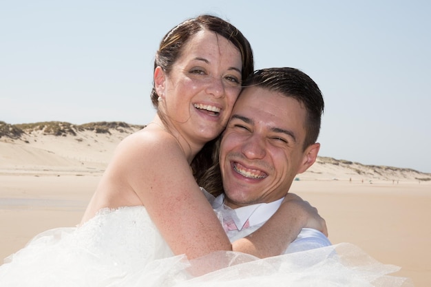 Hermosa pareja de novios en la playa con vestido de novia