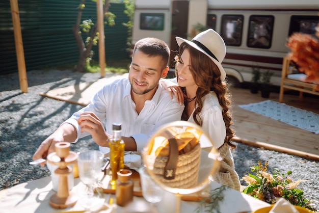 Hermosa pareja de novios se ríe y se besa relajándose en un campamento de rv en un remolque Momento romántico