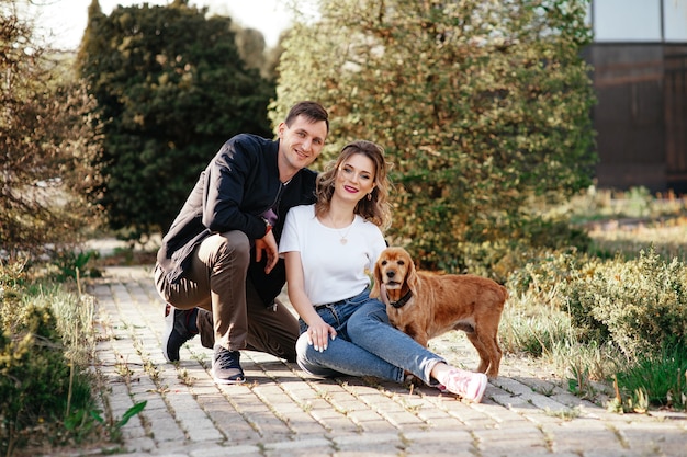 Foto hermosa pareja con un perro en la hierba