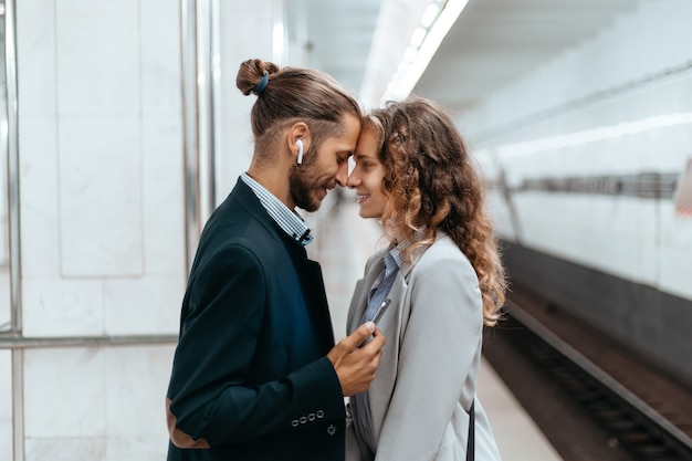 hermosa pareja de pie en la plataforma del metro