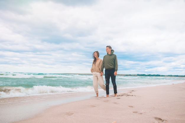 Hermosa pareja en la playa con cielo nublado