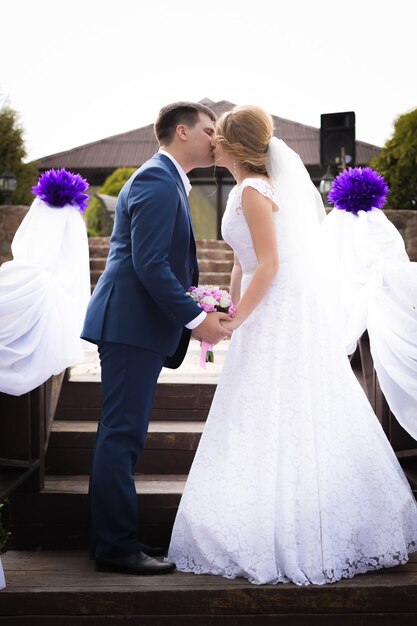 Hermosa pareja de recién casados de pie cara a cara y besos