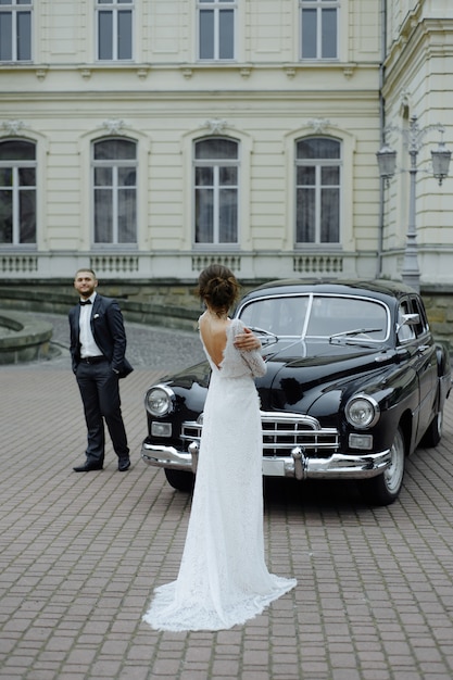 Hermosa pareja retro contra coches de época