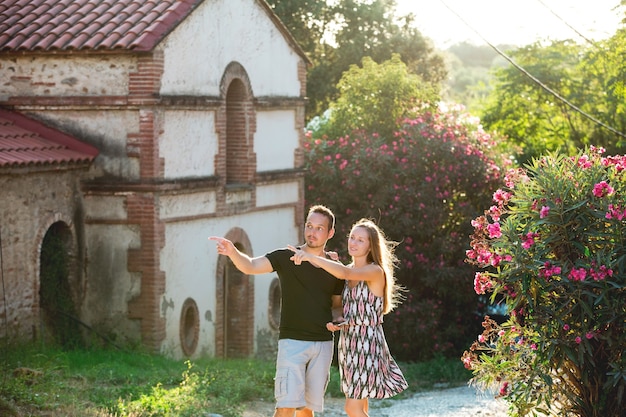 Hermosa pareja romántica hombre y mujer adultos jóvenes caminando por el floreciente casco antiguo