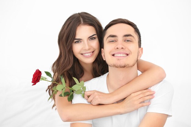 Hermosa pareja con rosa sobre fondo claro