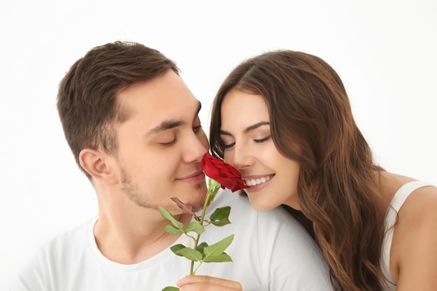 Hermosa pareja con rosa sobre fondo claro