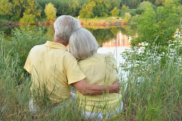 Hermosa pareja senior abrazándose en la vista trasera del parque