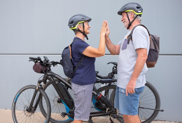 Hermosa pareja senior activa disfrutando de la actividad deportiva con sus bicicletas eléctricas estilo de vida saludable durante la jubilación y el concepto de movilidad sostenible