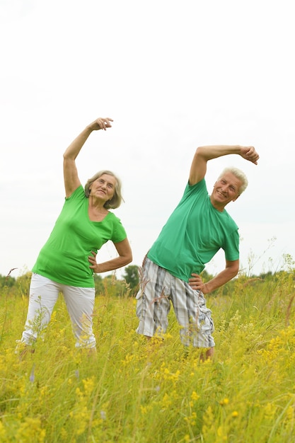 Foto hermosa pareja senior feliz haciendo ejercicios en el campo